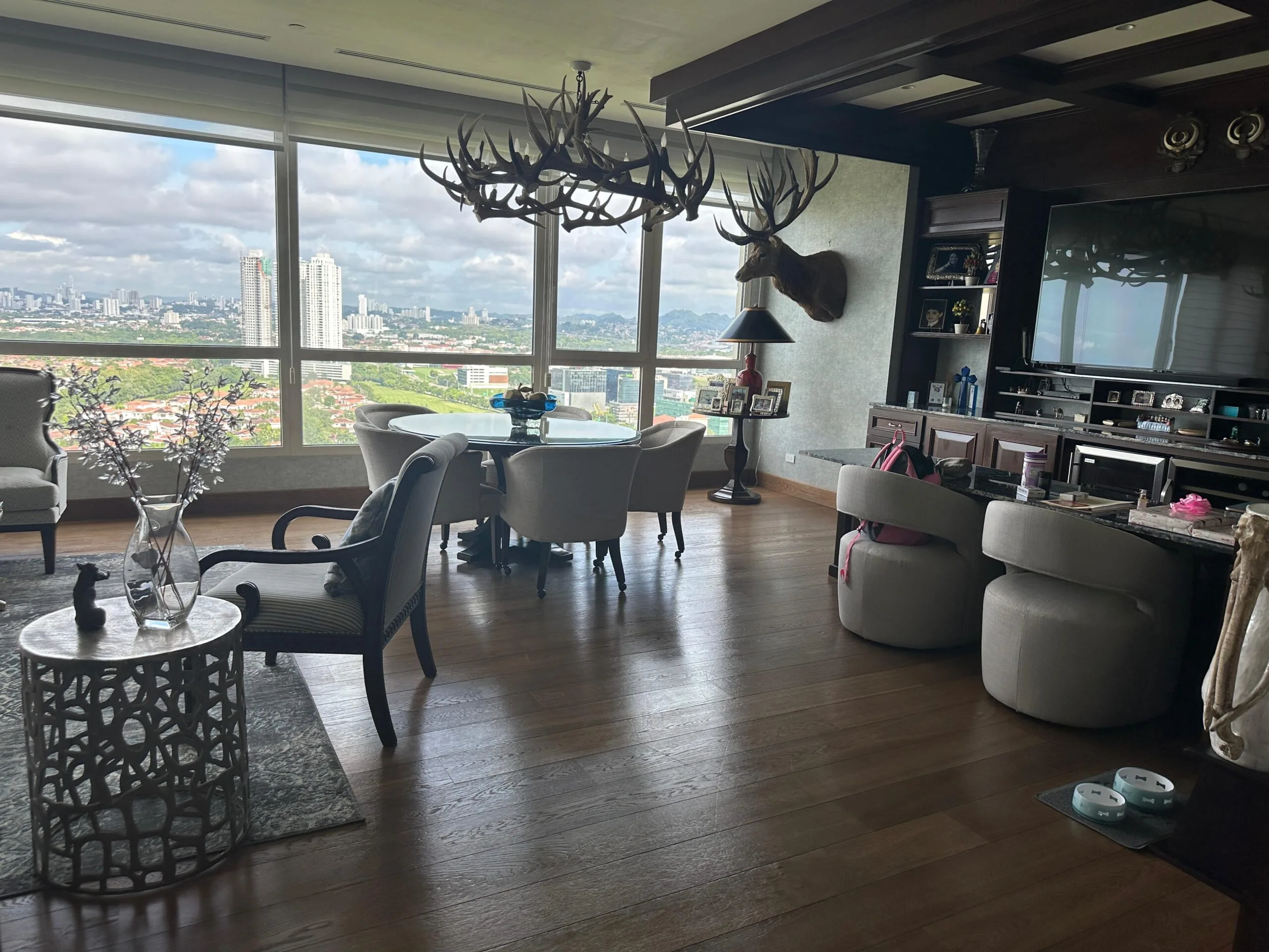 Open plan living room with antler chandelier and panoramic city views in the 608 m² luxury apartment at Santa Maria Golf & Country Club, Panama City
